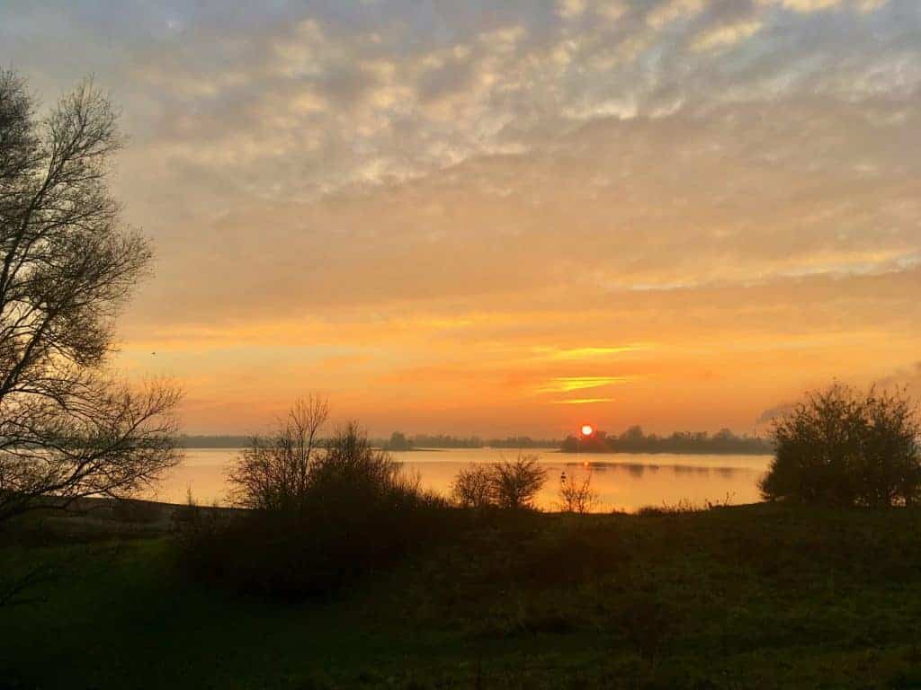 Prachtige zonsopgang boven de rivier op 't Gelders Eiland met kleurrijke hemel en rustige waterrefle.