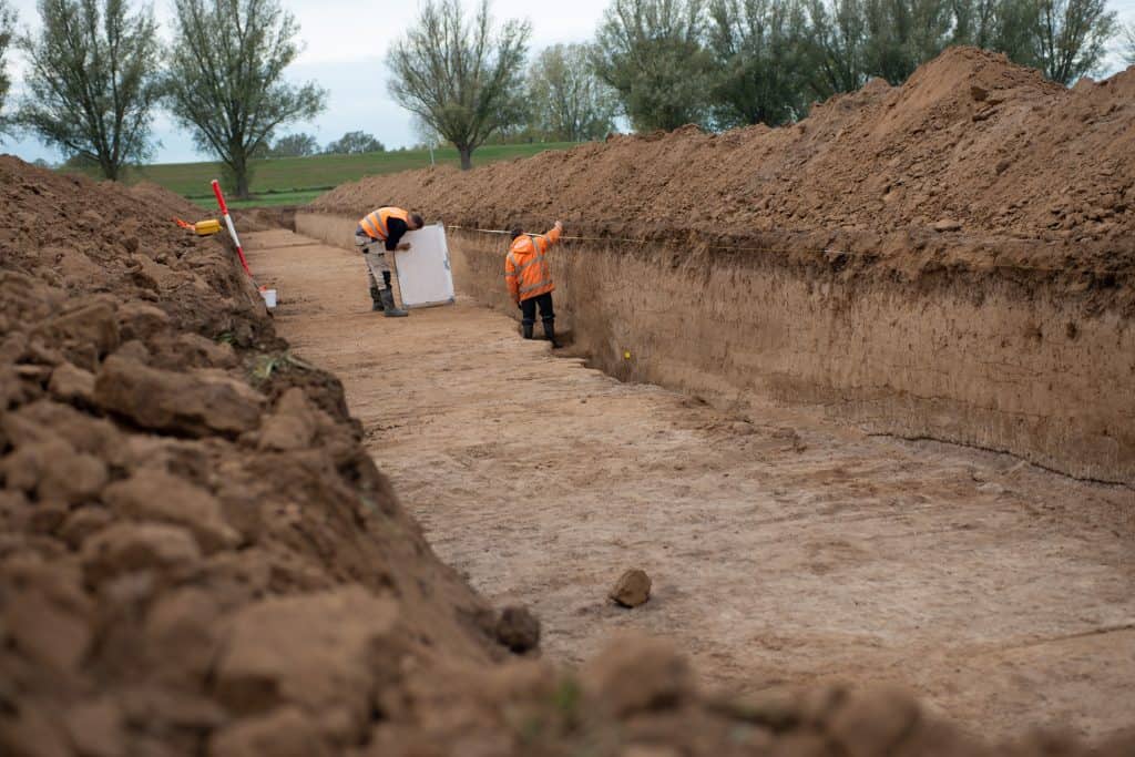 Archeologisch onderzoek op 't Gelders Eiland met onderzoekers in oranje vesten.