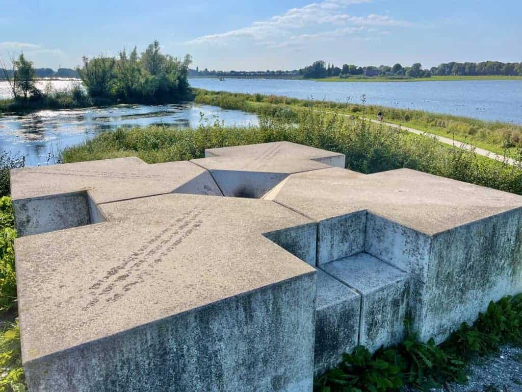 Monument op 't Gelders Eiland met uitzicht op rivier en natuur.