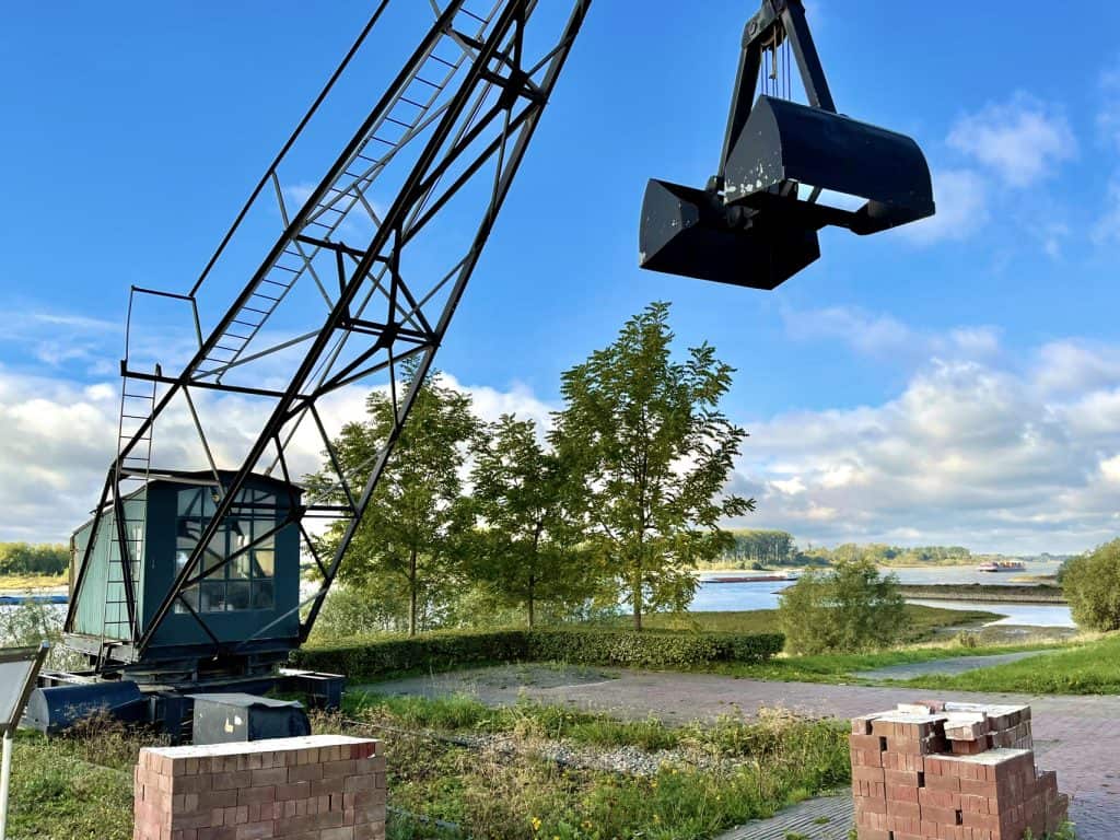 Industriële kraan op 't Gelders Eiland met uitzicht op water en groen landschap, typisch voor de reg.
