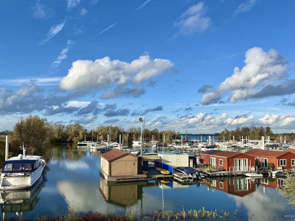 Haven op 't Gelders Eiland met boten en kleurrijke huisjes onder een blauwe hemel.