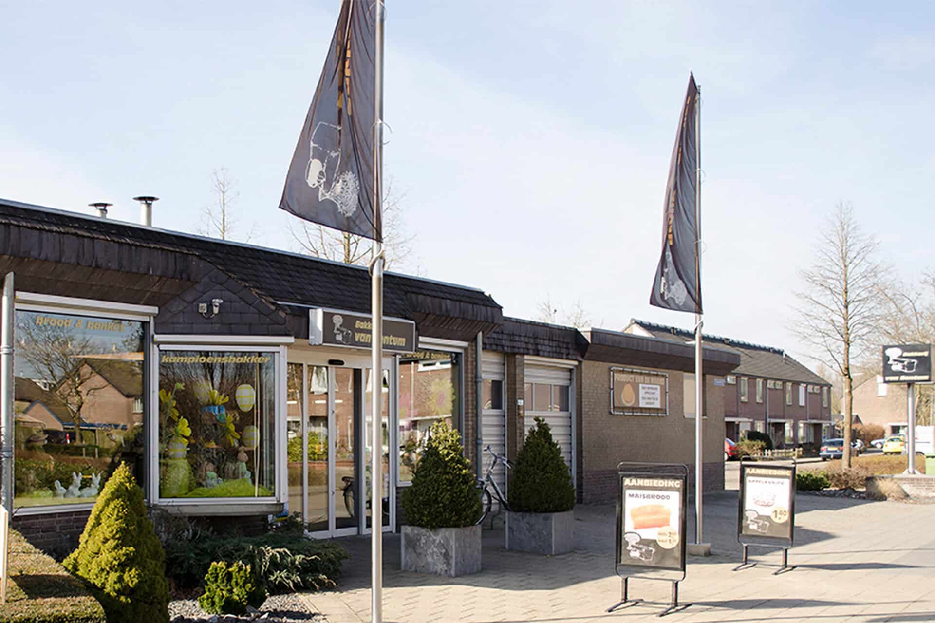 Bakkerij van Bentum met vlaggen en reclameborden op 't Gelders Eiland.