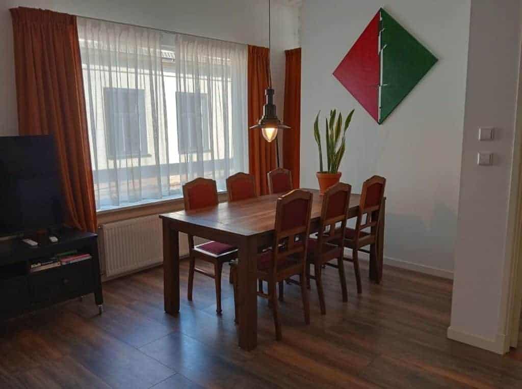 Eethoek met houten tafel en zes stoelen in gezellige kamer.