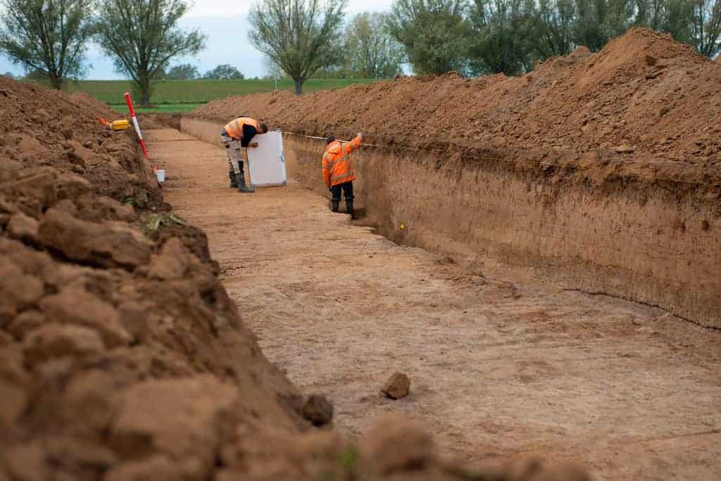 Archeologisch onderzoek op 't Gelders Eiland met arbeiders die de bodem onderzoeken.