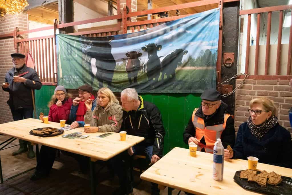 Gezellige groep mensen aan tafel op 't Gelders Eiland tijdens een evenement.