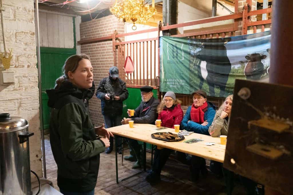 Groepsbijeenkomst op 't Gelders Eiland met gids en deelnemers in een gezellige setting.