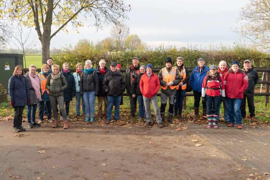 Gezelschap wandelaars op 't Gelders Eiland in de natuur, herfstkleuren en open landschap.