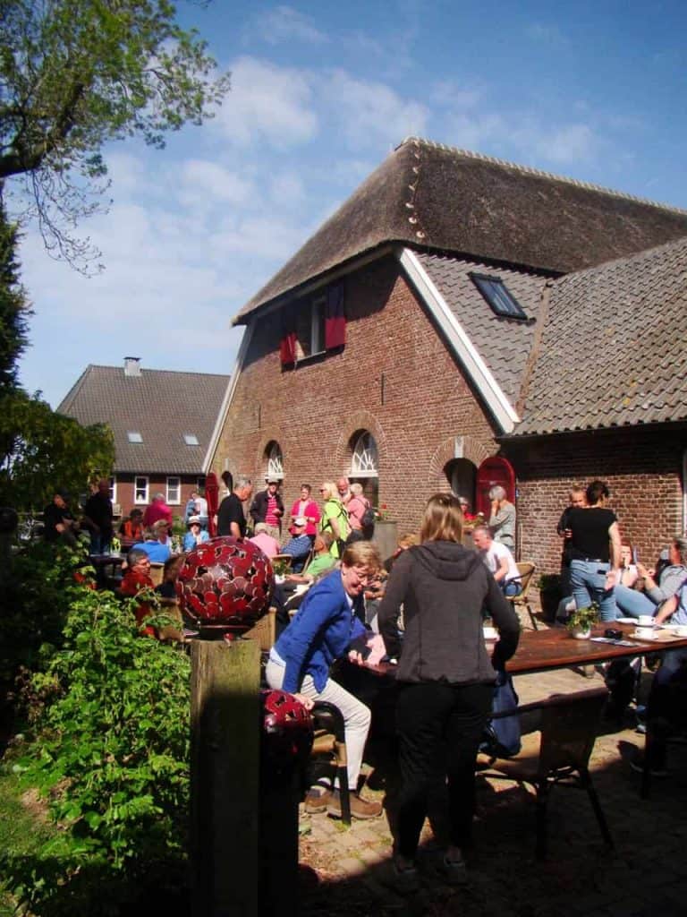 Gezellig buitenfeest op 't Gelders Eiland met mensen en historische gebouwen.