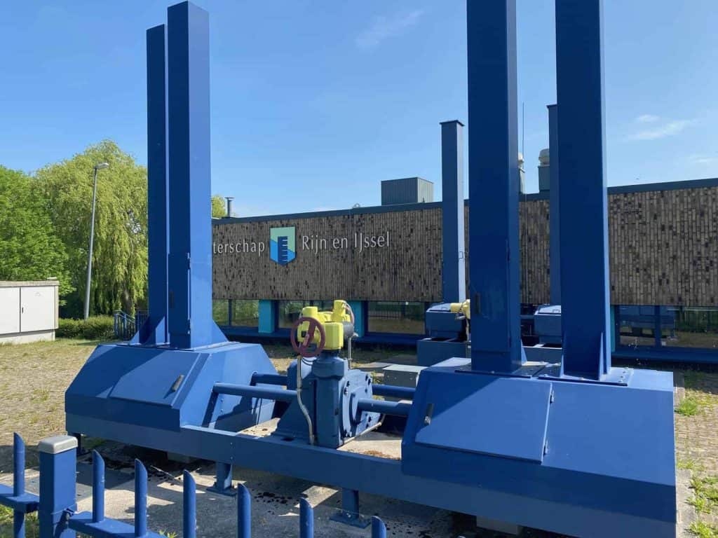 Blauwe waterpompinstallatie op 't Gelders Eiland, met moderne technische apparatuur en groene omgevi.