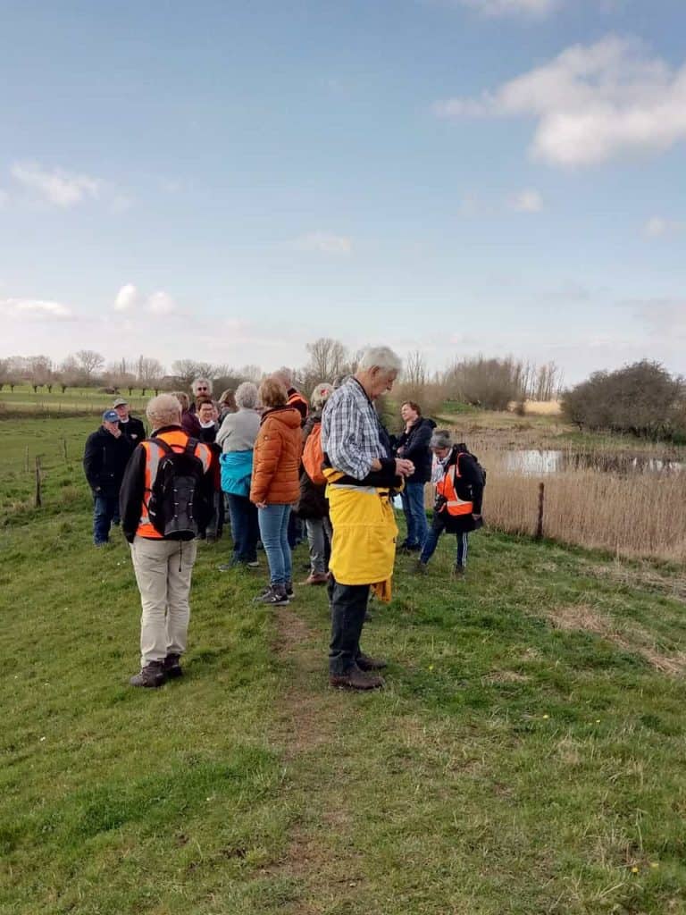 Gezelschap wandelaars op 't Gelders Eiland genieten van de natuur en het landschap.
