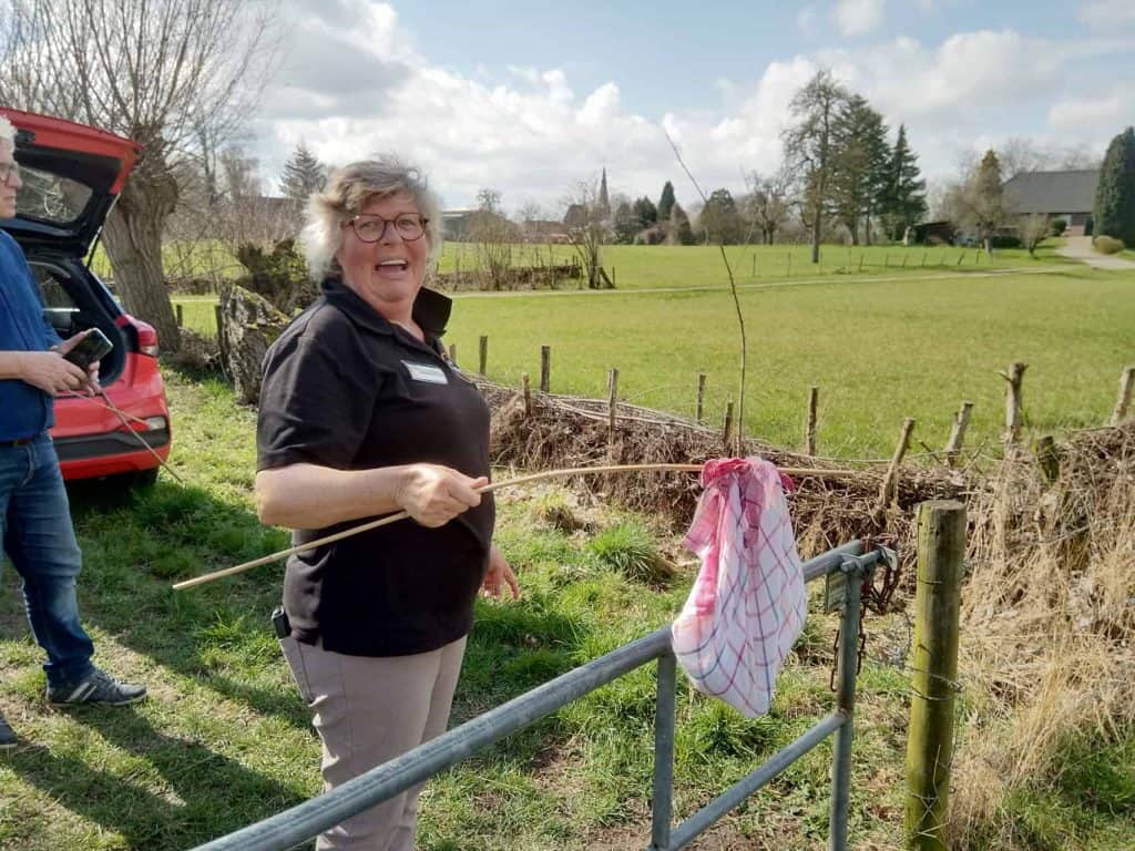 Gezellige vrouw met stok in landelijke omgeving op 't Gelders Eiland.