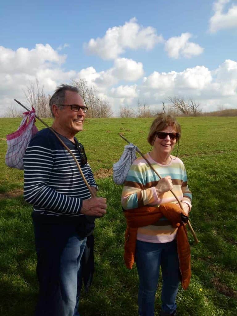 Gezellig paar wandelen op 't Gelders Eiland met wandelstokken en rugzakken. Prachtige groene omgevin.