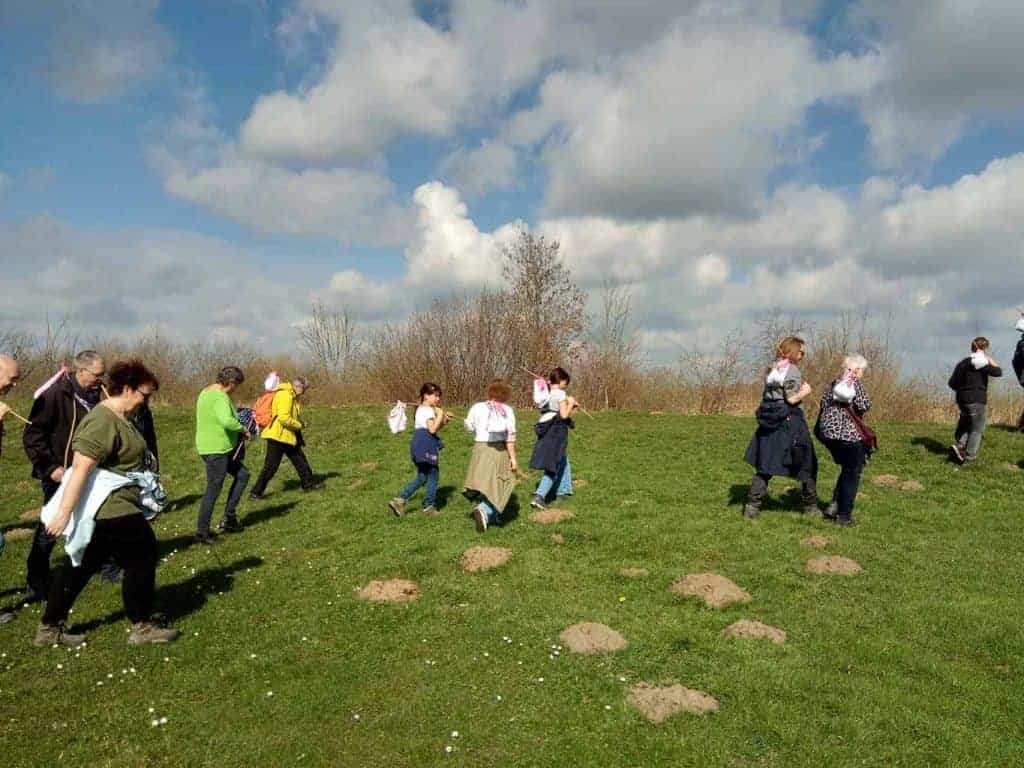 Gezinnen wandelen op 't Gelders Eiland in de natuur onder een bewolkte hemel.
