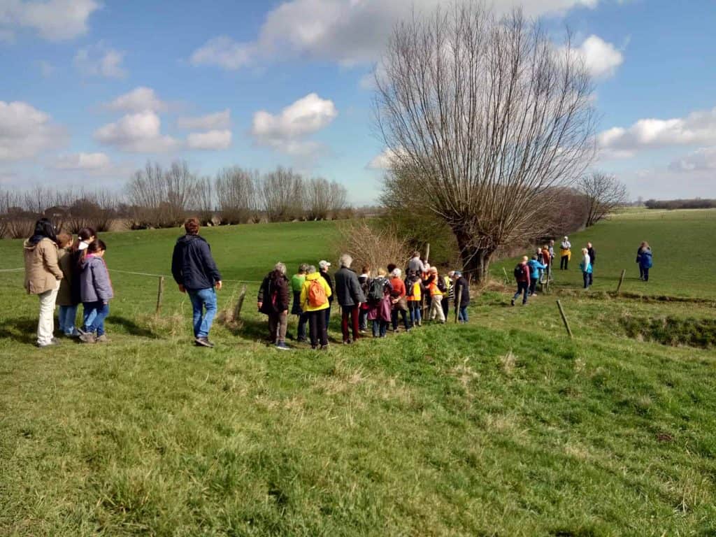 Gezelschap wandelaars op 't Gelders Eiland genieten van de natuur en het landschap.
