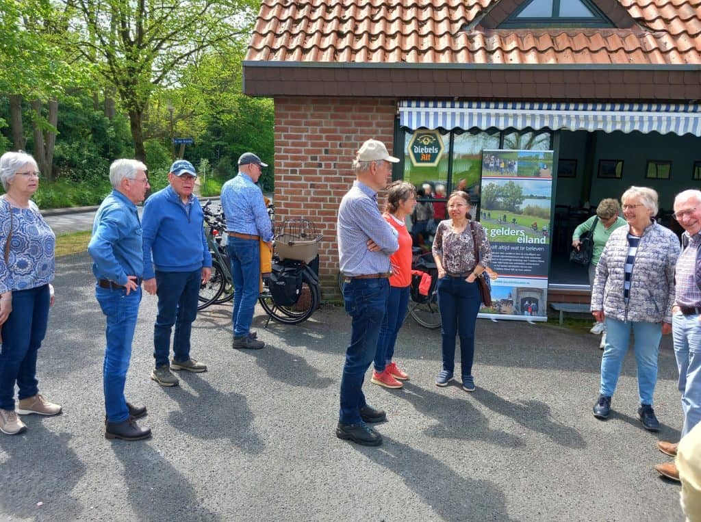 Gezelschap toeristen bij informatiepunt op 't Gelders Eiland in Nederland.