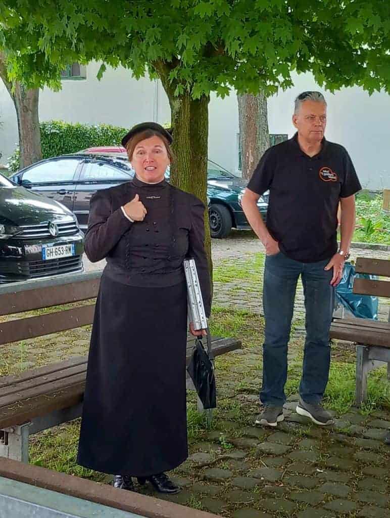 Een vrouw en een man staan onder een boom op 't Gelders Eiland, ontspannen en in gesprek. De omgevin.
