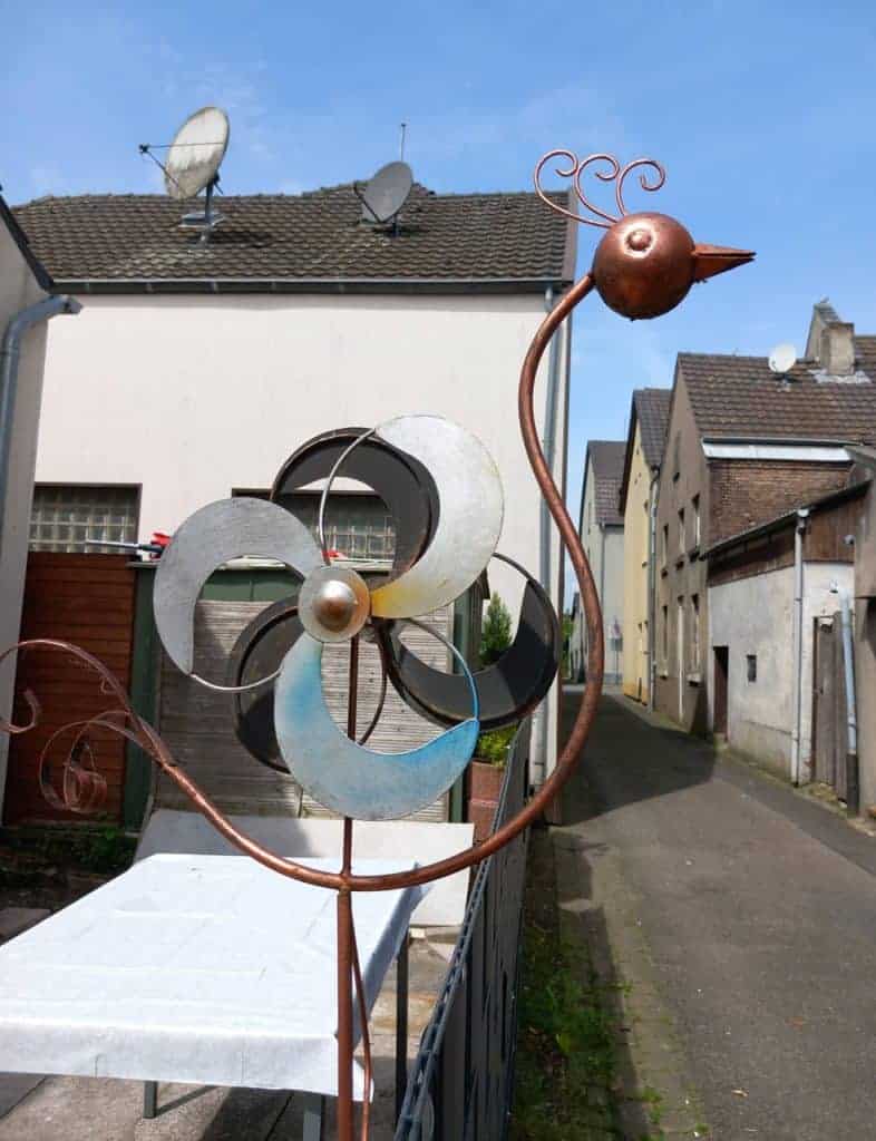 Kunstzinnige metalen vogelbeeld op 't Gelders Eiland, kleurrijk en speels, in een rustige straat met.