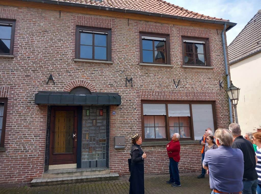 Historisch huis op 't Gelders Eiland met groep bezoekers buiten.