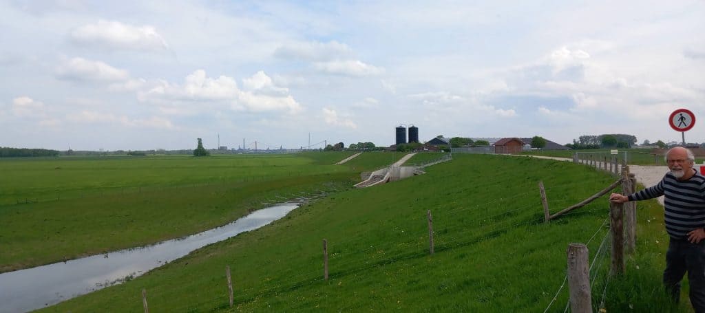 Gezicht op 't Gelders Eiland met groene weilanden en waterpartijen in de omgeving.