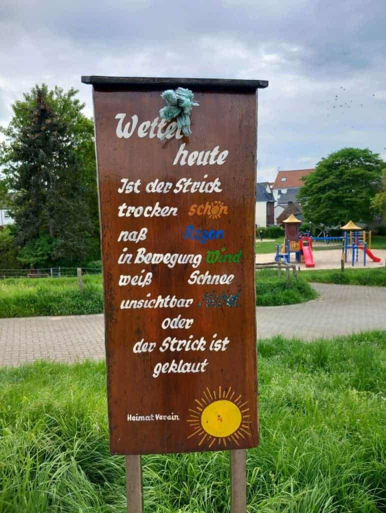Zonneschijn en grasveld bij speeltuin op 't Gelders Eiland, met waarschuwingsbord over het weer en k.