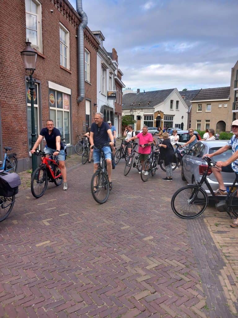 Fietsen op 't Gelders Eiland, levendige straat met fietsers en historische gebouwen.