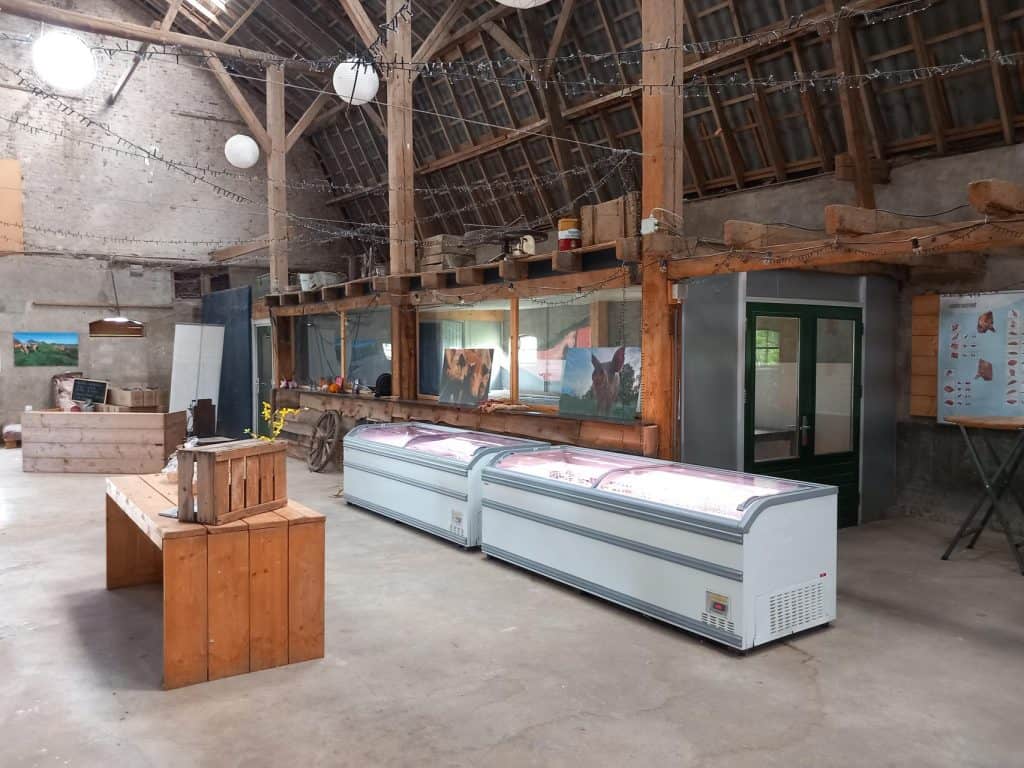Koelvitrine en interieur van een boerderijwinkel op 't Gelders Eiland, met lokale producten en infor.