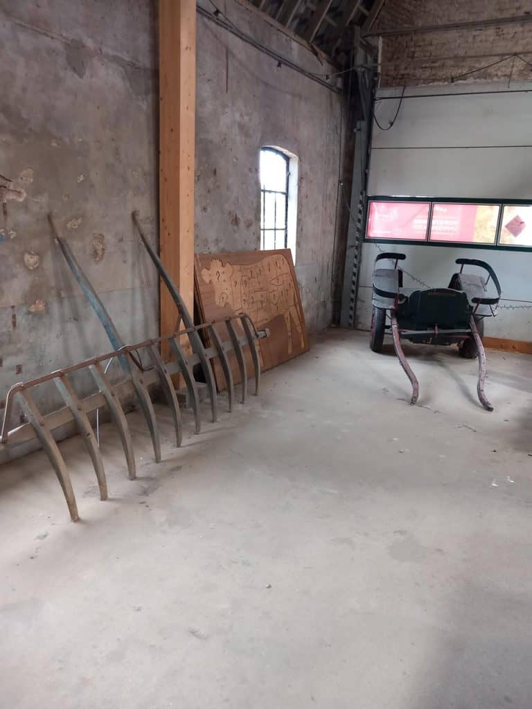 Oude boerderijwerkzaamheden op 't Gelders Eiland met landbouwgereedschap en bouwmaterialen.