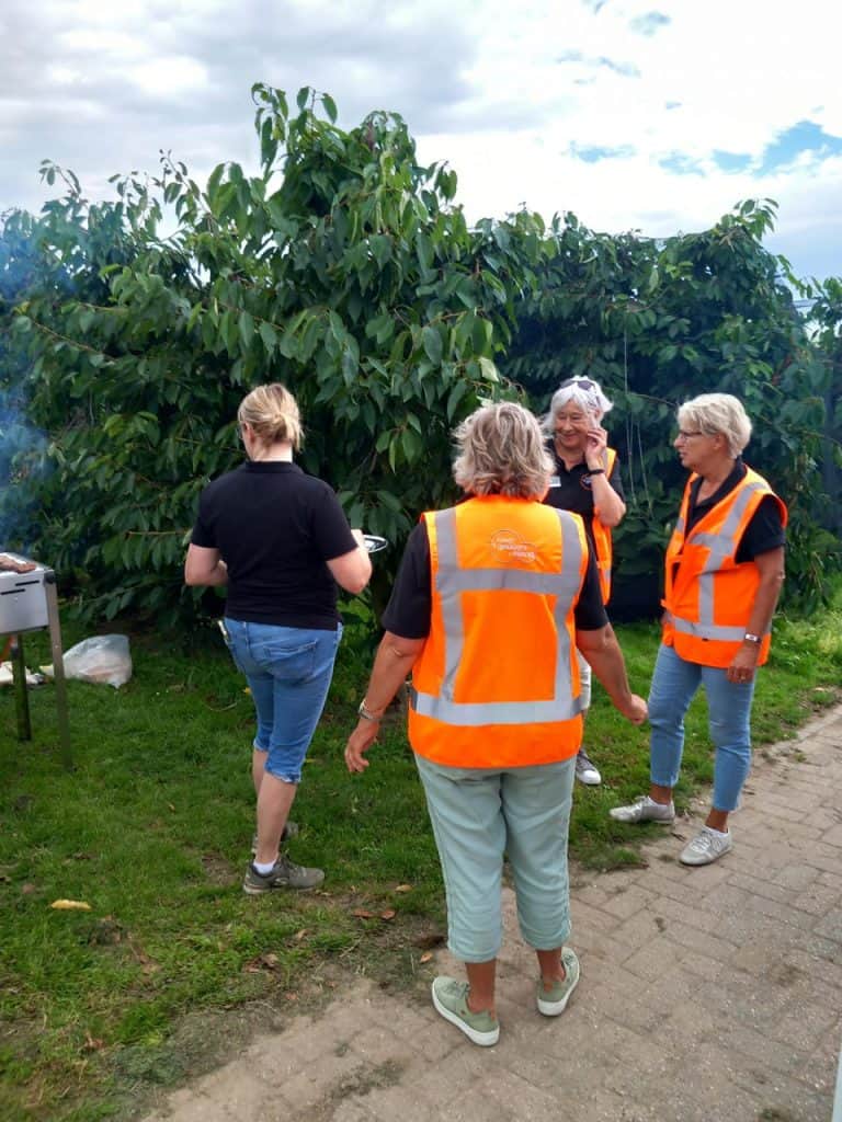 Gezelschap van vier mensen in oranje veiligheidsvesten tijdens wandeling op 't Gelders Eiland.