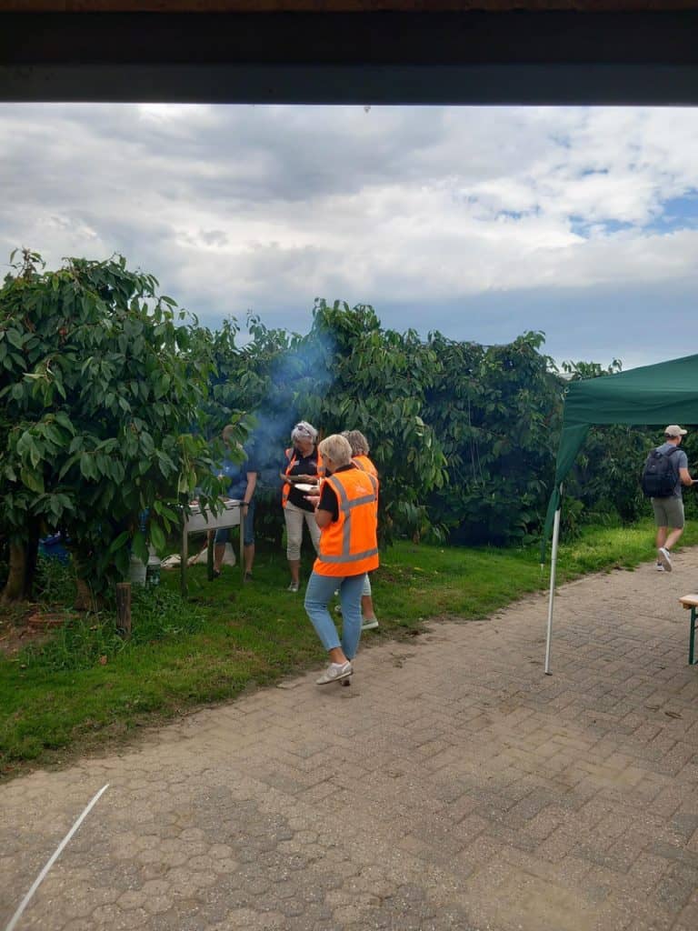 Rookwolk boven groene boomgaard op 't Gelders Eiland tijdens een buitenactiviteit.