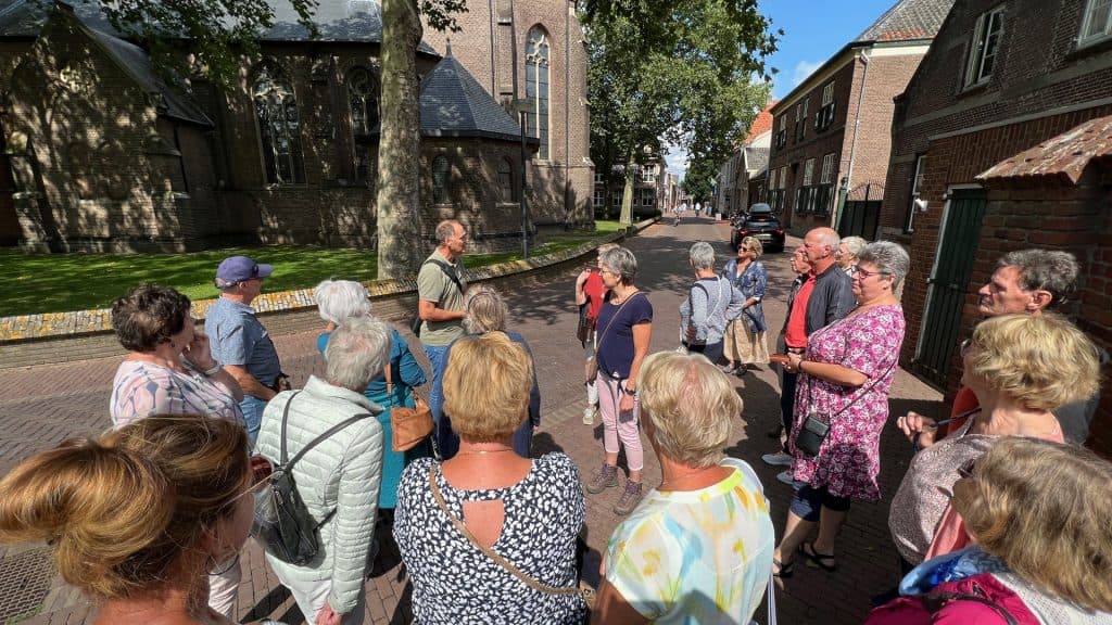 Gezelschap toeristen op 't Gelders Eiland tijdens een rondleiding in de historische wijk.