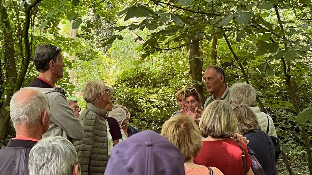 Gezelschap wandelaars in bos op 't Gelders Eiland.