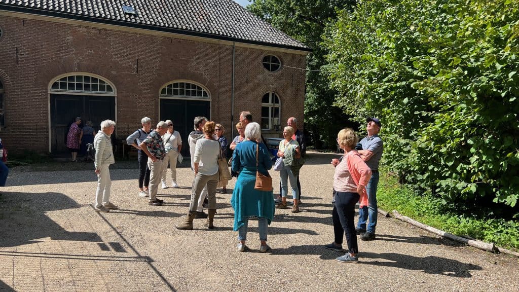 Gezelschap wandelaars op 't Gelders Eiland in de buitenlucht.