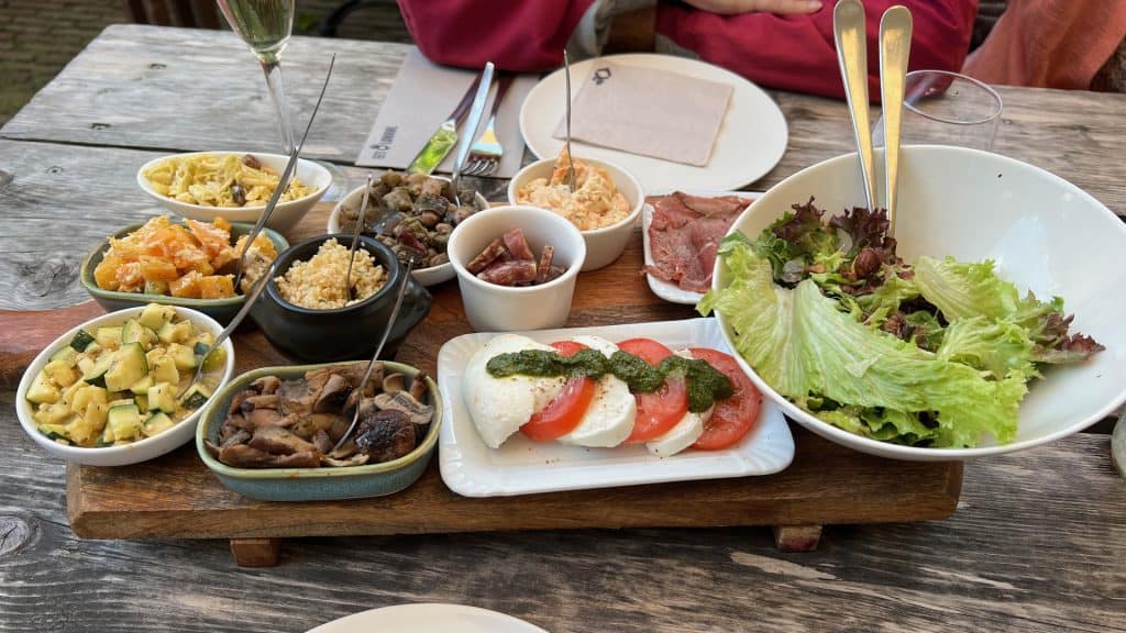 Gezellig gedeeld tapasplateel met diverse hapjes op houten tafel op 't Gelders Eiland.