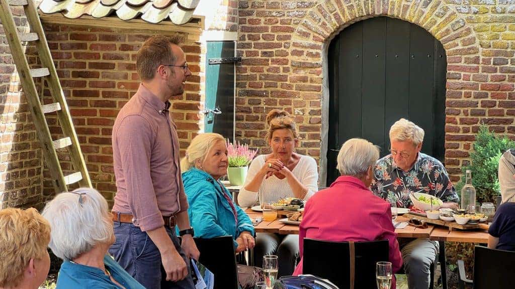 Gezellig gezelschap geniet van een maaltijd op een terras in 't Gelders Eiland. Vrienden en familie.