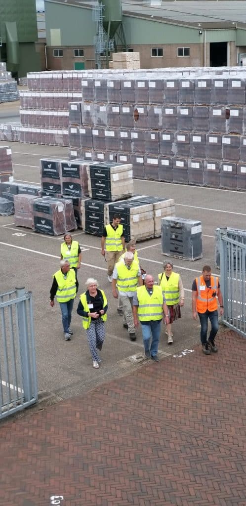 Hoge stapelaars in een magazijn met gestapelde bouwmaterialen op 't Gelders Eiland.