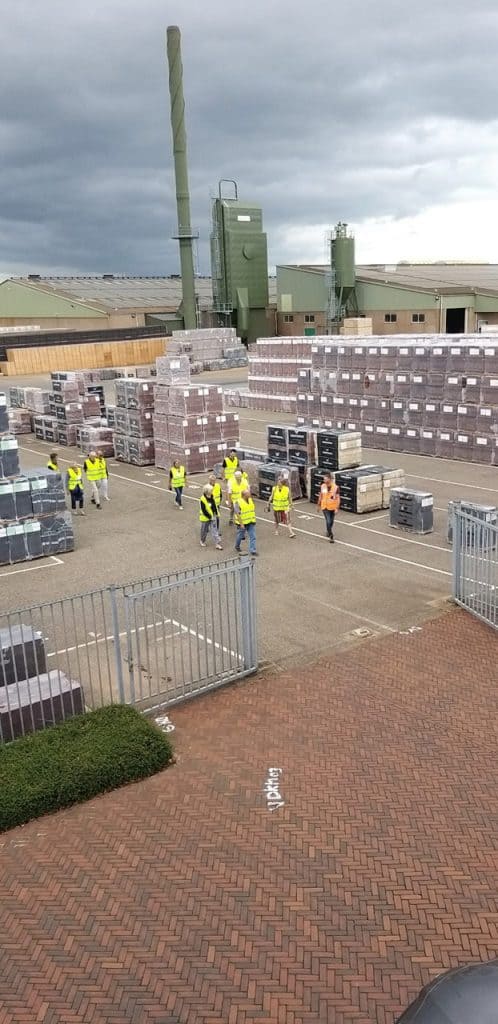 Houtverwerkingsbedrijf op 't Gelders Eiland met stapels hout en werknemers in veiligheidskleding.