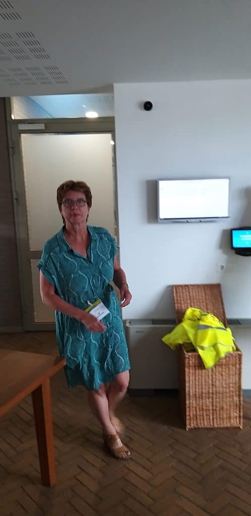 Gezellige vrouw in blauwe jurk in 't Gelders Eiland ontmoetingsruimte.