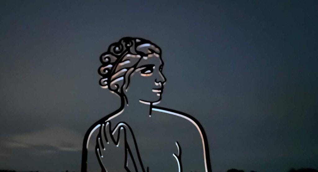 Zonsondergang over 't Gelders Eiland met silhouet van een vrouw.