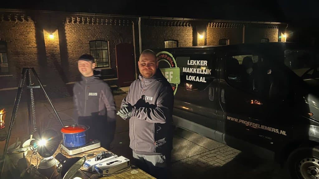 Gezellige straatmarkt op 't Gelders Eiland met lokale verkopers en bezoekers in avondlicht.