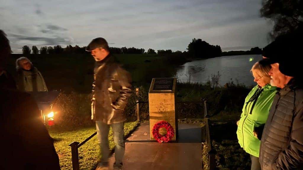 Herdenkingsmonument bij 't Gelders Eiland met mensen die de herinnering eren in de schemering.