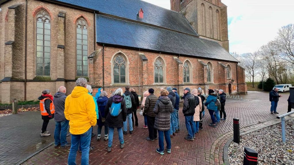 Historische kerkgroep op 't Gelders Eiland, toeristen en gidsen bij oude kerk.