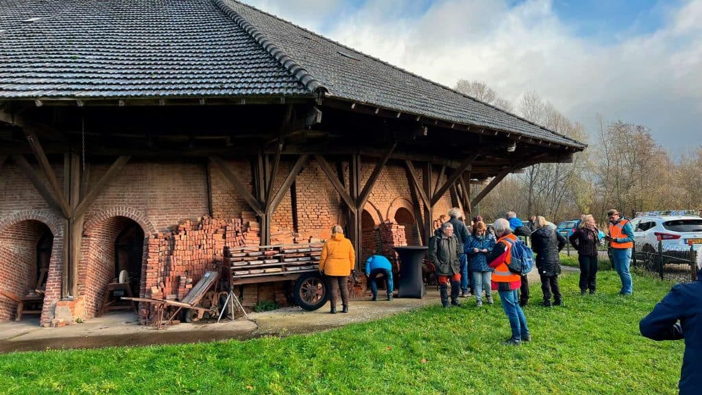 Hollandse molen op 't Gelders Eiland met bezoekers en gidsen in de buitenlucht.