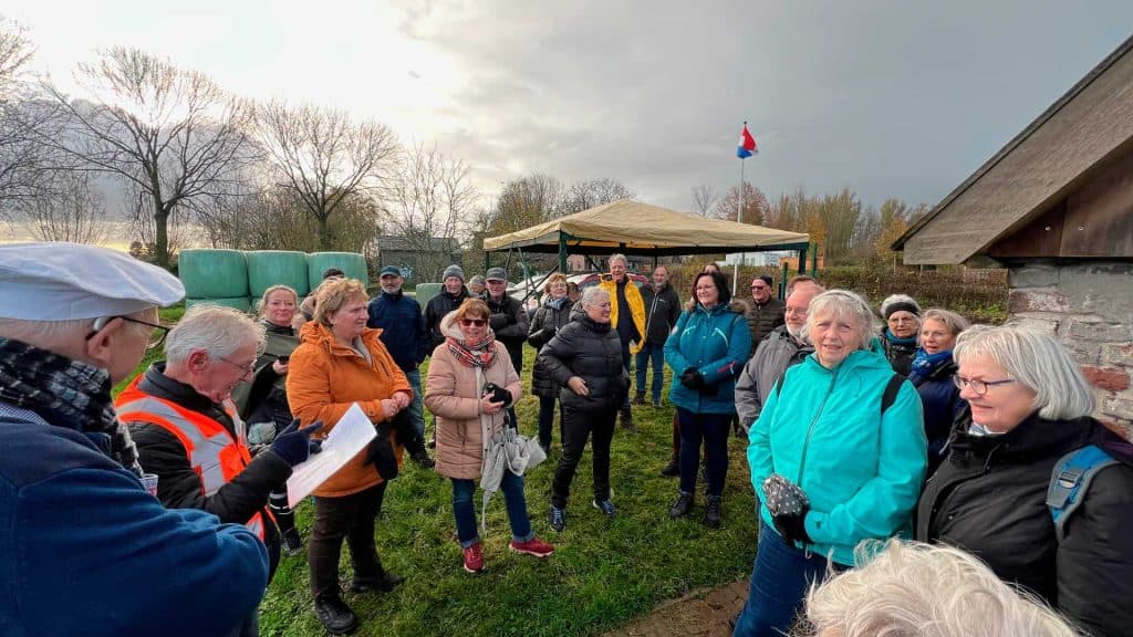 Gezelschap wandelt en luistert tijdens een excursie op 't Gelders Eiland in de natuur.