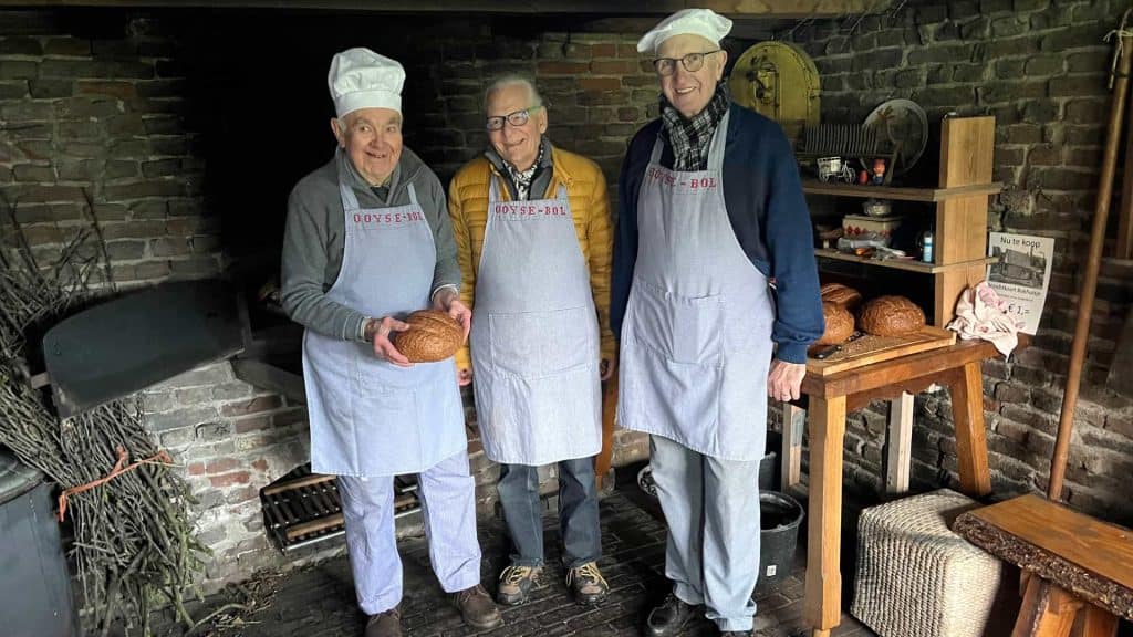 Traditionele bakkerij op 't Gelders Eiland met drie bakkers in oude ambachtelijke kleding.