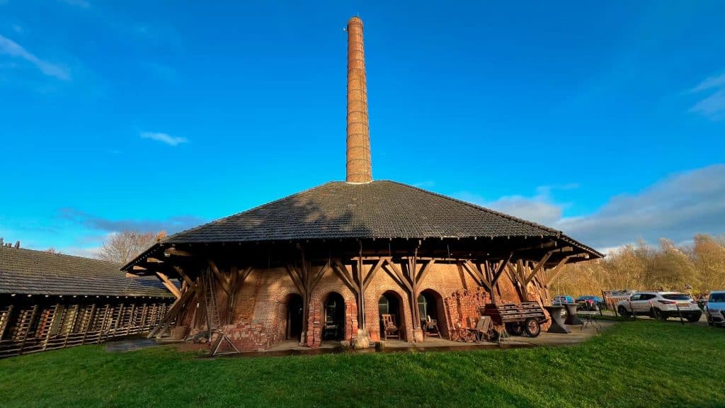 Houten gebouw met hoge schoorsteen op 't Gelders Eiland, historische industriële site.