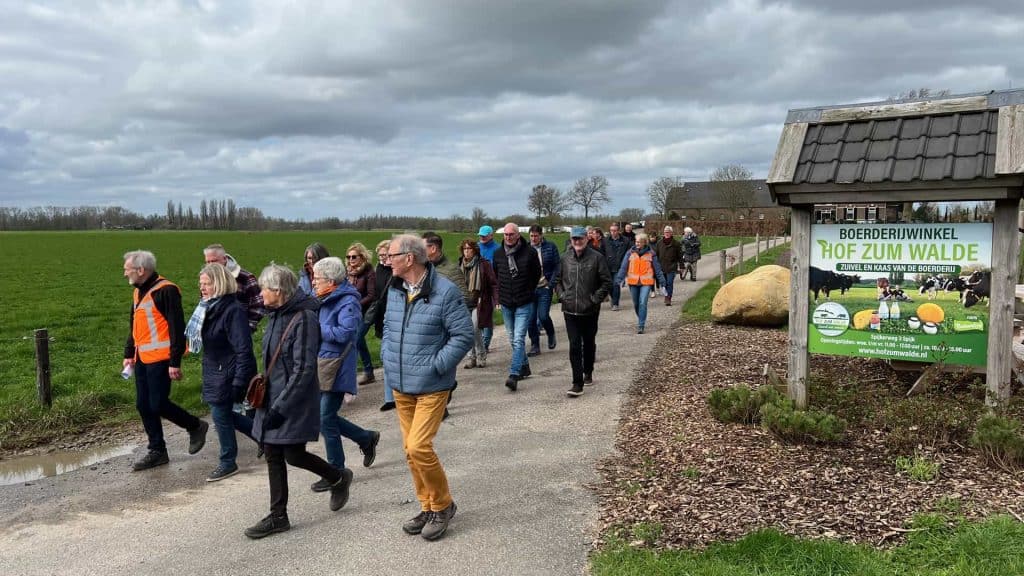 Gezellige groep wandelaars op 't Gelders Eiland, genieten van de natuur en het landschap tijdens een.