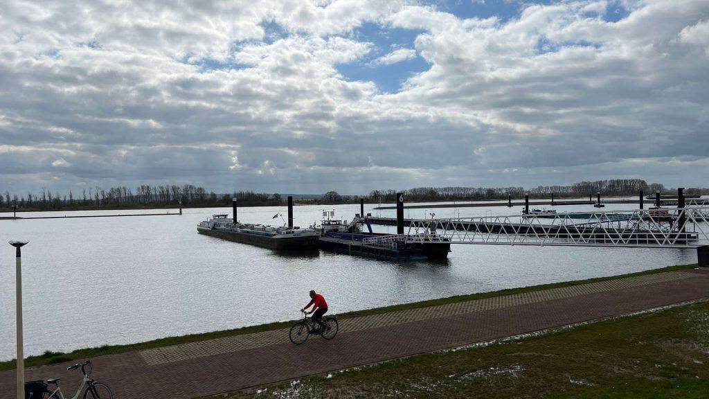 Zwemvijver op 't Gelders Eiland met wandel- en fietspad, onder een bewolkte hemel.