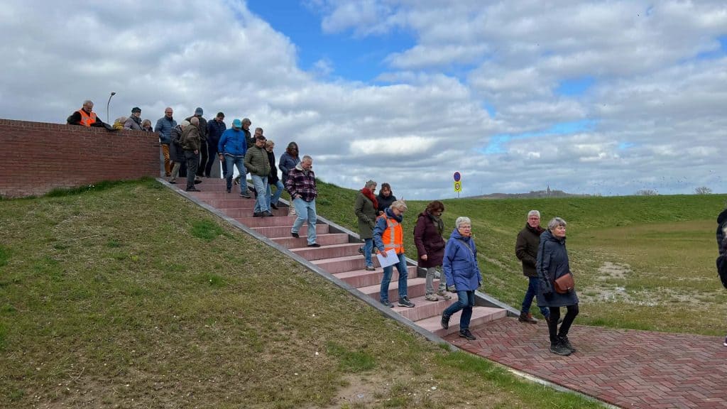 Gezellige groep wandelaars op 't Gelders Eiland, genietend van het uitzicht en de frisse lucht.