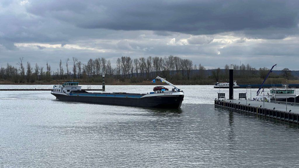 Zwarte boot op de rivier bij 't Gelders Eiland onder een bewolkte hemel.