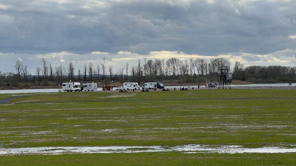 Kampeerplaatsen op 't Gelders Eiland met caravans en camperplaatsen onder een bewolkte hemel.